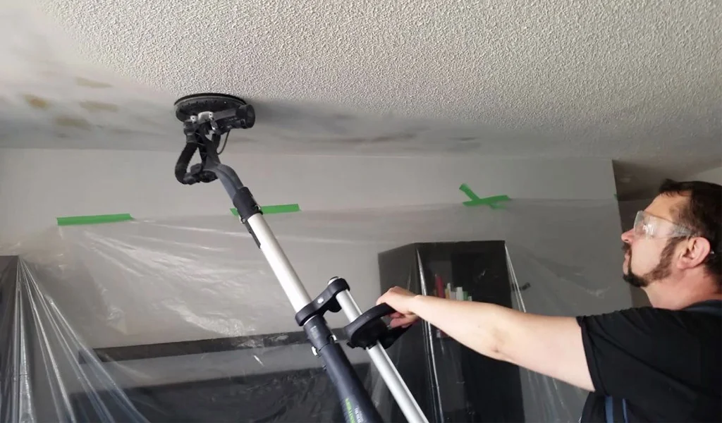 guy sanding textured ceiling
